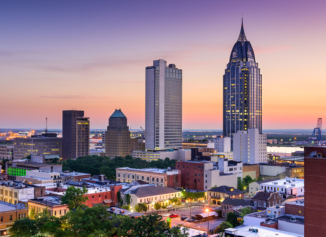 Contact - View of Mobile Alabama Skyline in the Evening with Skyscrapers Against a Colorful Sky