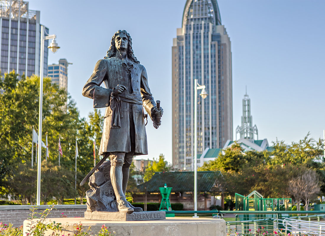 Mobile, AL - Pierre d'Iberville Statue in Cooper Riverside Park in Mobile Alabama with Commercial Buildings in the Background Against a Clear Blue Sky
